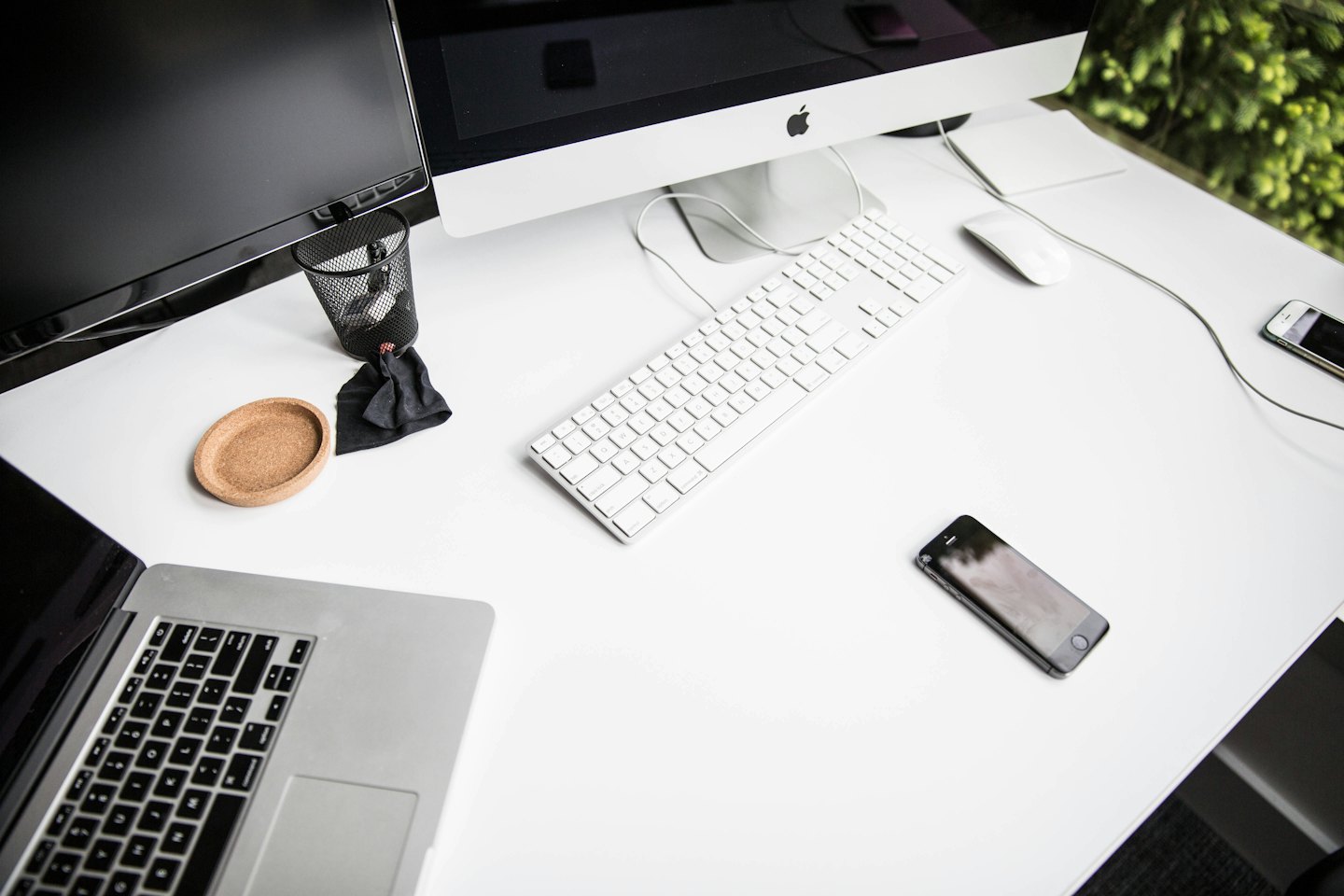 Açık dizüstü bilgisayar ve ofis malzemeleriyle modern beyaz masa.