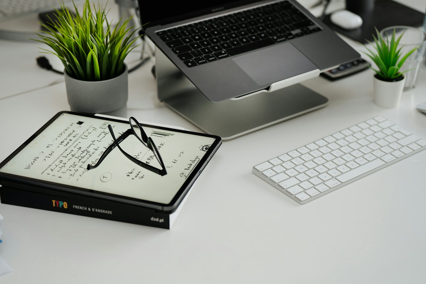 Temiz, düzenli, modern bir masada dizüstü bilgisayar ve tablet.
